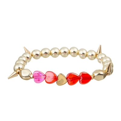 Il metallo di colore dell'oro borda il cuore che di rosa il braccialetto fatto a mano ha messo per la ragazza come regalo